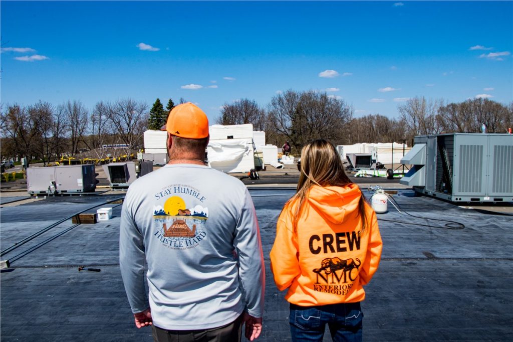 Molly and Chad overseeing a flat roof replacement in progress.