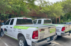 Two trucks featuring the cobranded logo for NMC in partnership with Apple Roofing.